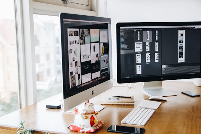Two monitors with web design layouts