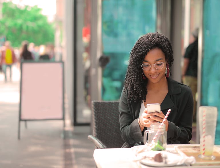 A smiling woman using her smartphone